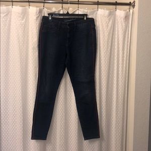 Dark wash skinny jeans with red detailing